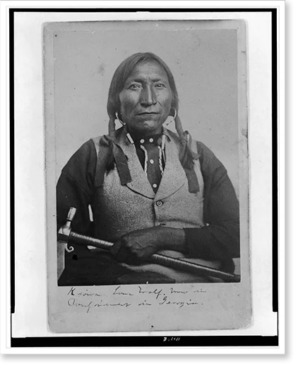 Historic Framed Print, [Lone Wolf, a Kiowa chief, half-length portrait, seated, facing front, holding tomahawk], 17-7/8