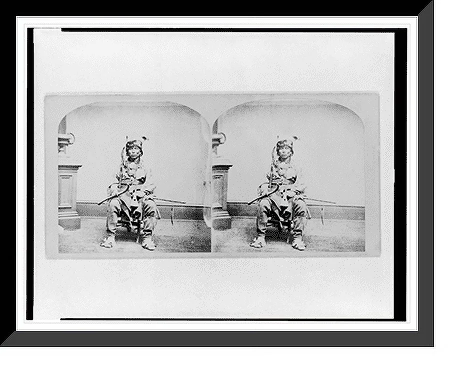 Historic Framed Print, [Winnebago man, full-length portrait, seated, facing front, holding tomahawk and club], 17-7/8" x 21-7/8"